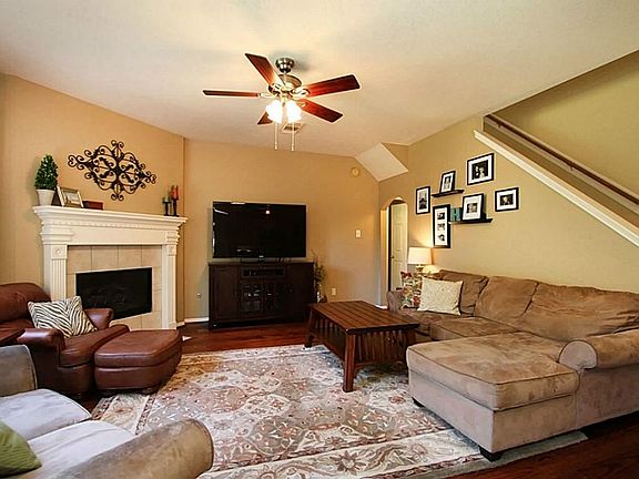The spacious living room has hardwood flooring and a wonderful tile surround gas fireplace with clas