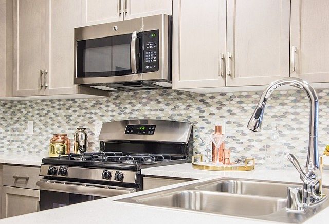 Stainless steel GE appliance package and durable quartz countertops.