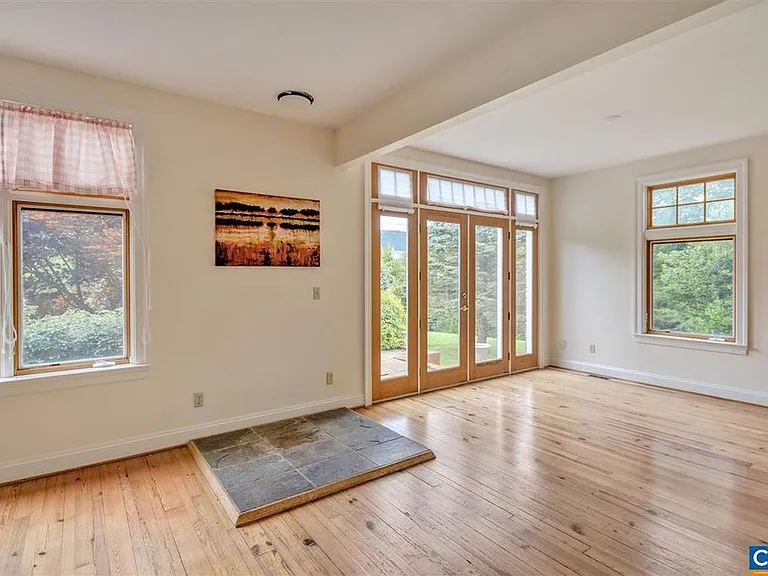 The living room is at the front of the house, part of the open floor plan that includes the kitchen. There's a hookup for a wood burning stove and you can step out onto the blue slate patio which has some lovely shade.