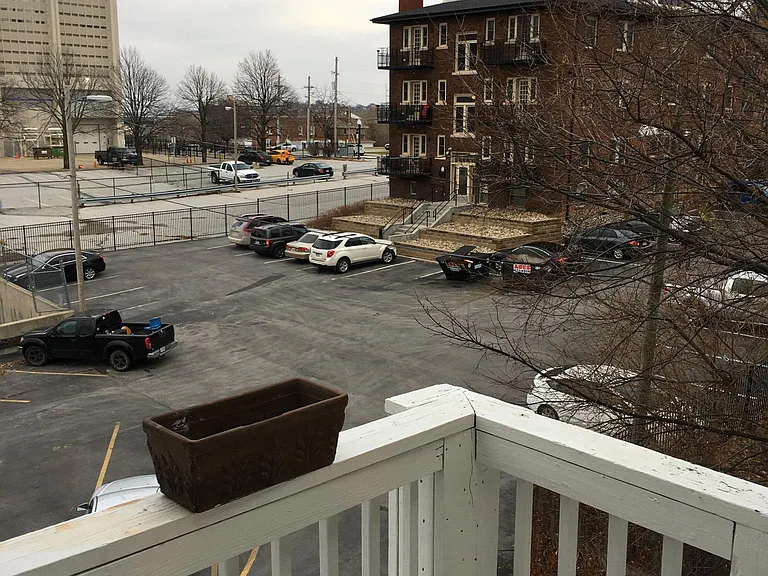 Landing atop fire escape looking into parking lot