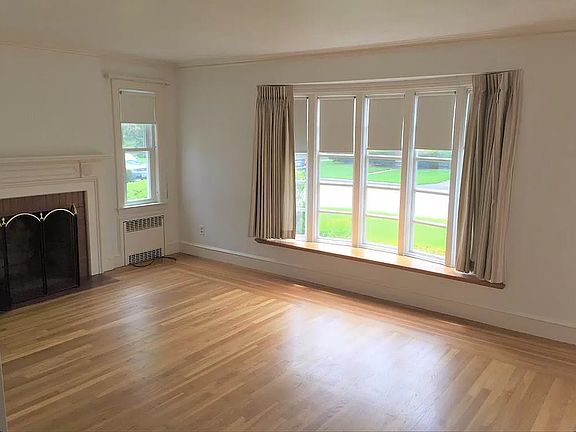 Living room and bay window.

Living room walls are now light gray and baseboard/crown molding/trim is white.