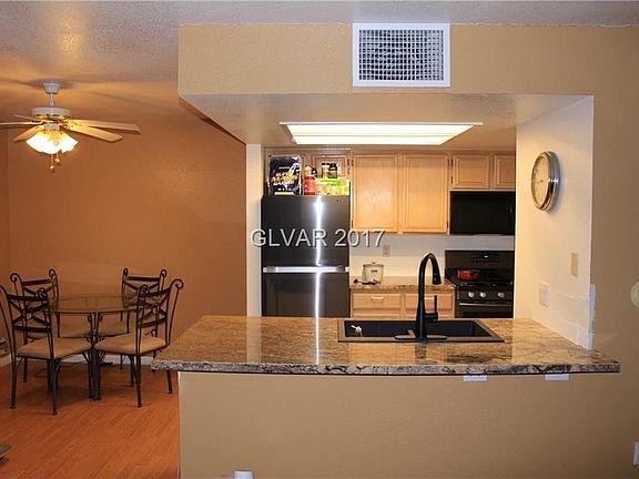 Kitchen View with Granite Counters, Laminate Floors and Partial Stainless Steel Kitchen Appliances
