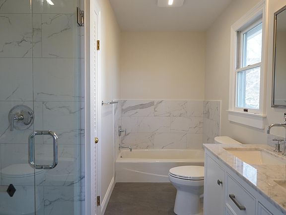 Fully updated master bath with marble counter, double sinks, stall shower and tub