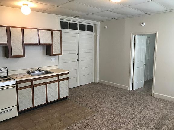 Living room looking at kitchen, front door and then bedroom door