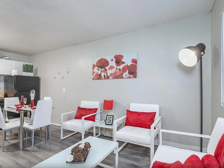 Open-concept floor plan with red accent decor and natural light