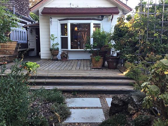 Large front deck has potted citrus plants, a mature orange tree, pomegranate, and a high yielding berry patch.