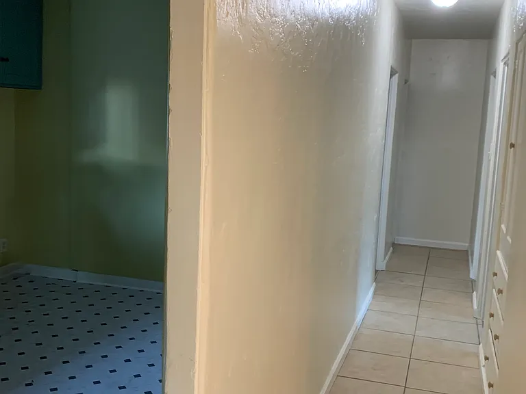 Hallway from dining room and kitchen leading to back two bedrooms and bathrooms.