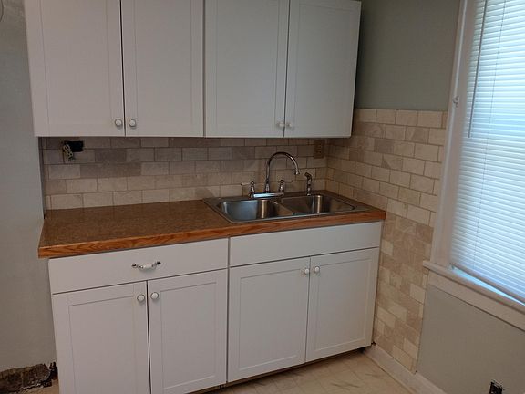 newly installed cabinets and sink area with tile