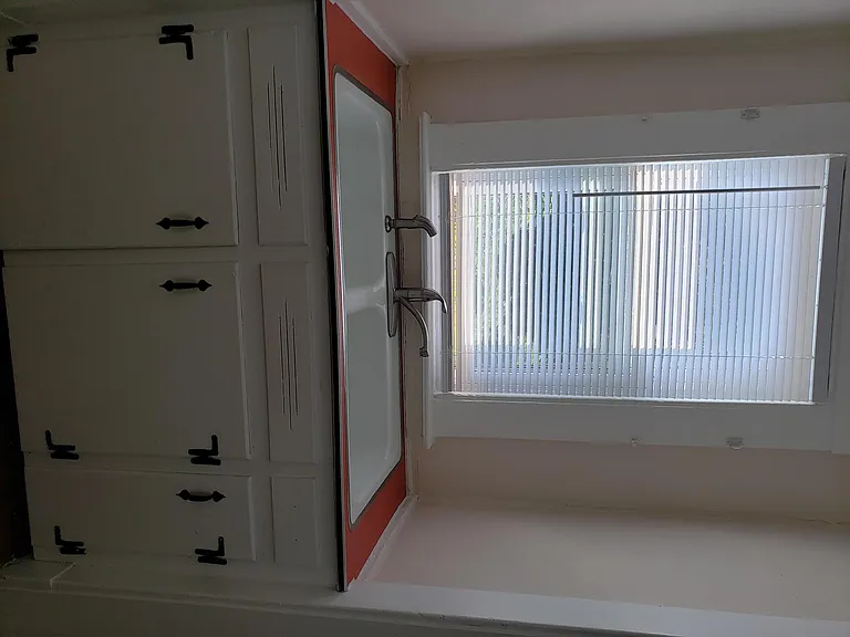 View of part of the kitchen which includes the sink and under storage area
