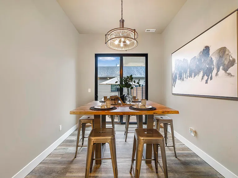 Dining Room With Custom Lighting and Patior Door To A Outside Patio Area