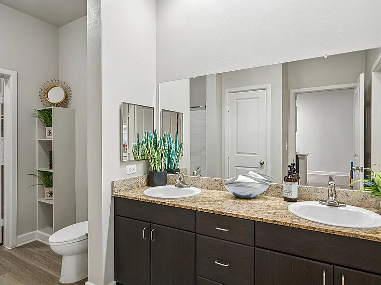 Experience luxury living with this modern bathroom featuring a walk-in shower and dual sinks.
