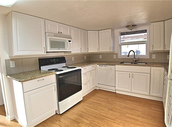Spacious kitchen with tons of cabinets, granite counter tops and tile backsplash.