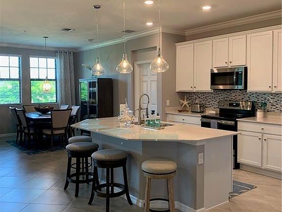 Kitchen with a center island with sink, pendant lighting, sink, and a breakfast bar area