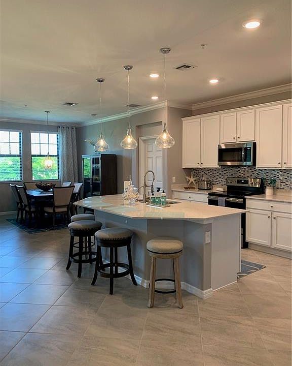 Kitchen with a center island with sink, pendant lighting, sink, and a breakfast bar area