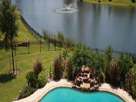 View from covered second story balcony of the pool and lake