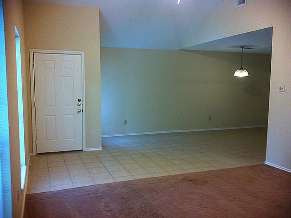FROM THE LIVING ROOM, A VIEW OF THE FRONT DOOR AND BREAKFAST AREA