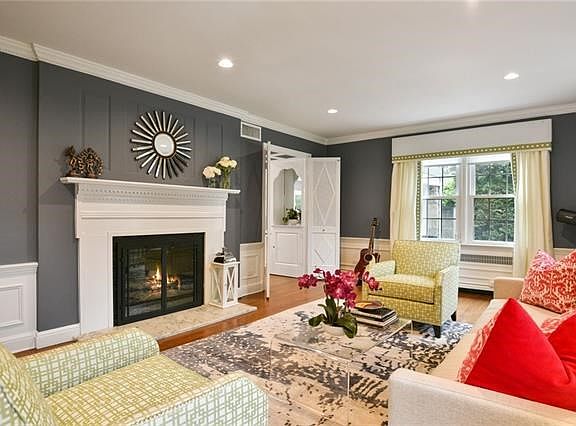 Bright living room with handsome mantled fireplace with new glass doors and marble hearth.