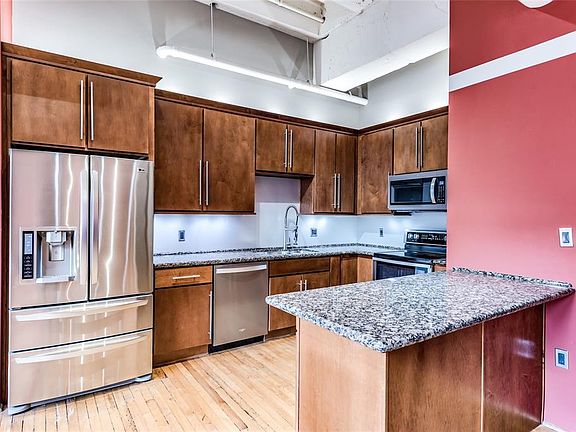 The Kitchen is sure to impress! Wood stained cabinetry with abundant storage, granite countertops, updated SS appliances and Pantry with Elfa organization system! This isn't your typical tiny condo Kitchen.