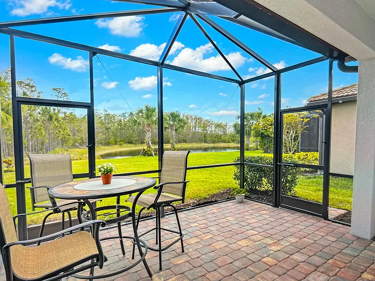 Extended lanai with pub table, couch, coffee/end table and new Weber gas grill overlooking the pond & preserve teeming with birds and wildlife