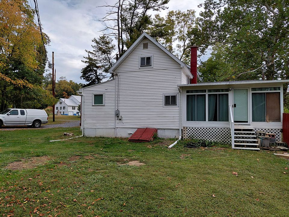 Large sunporch on the right includes separate entrance. Yard light above the door. Steps to the basement are red.