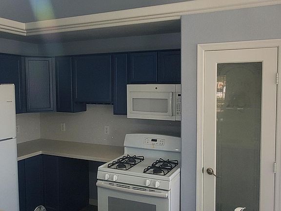 Gas Stove ,microwave and Refrigerator with Pantry door.Other door entry into Car Garage