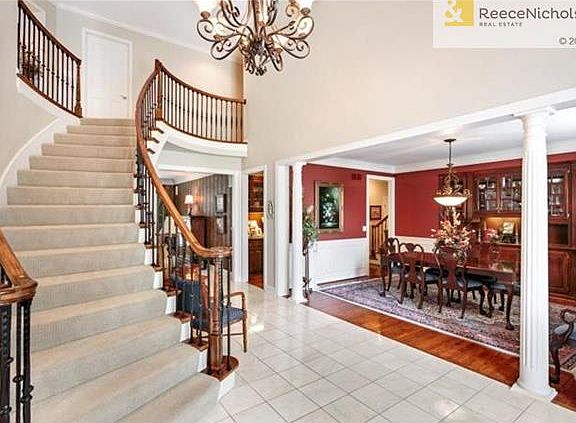 The large entry is enhanced by the curved staircase and wrought iron chandelier.