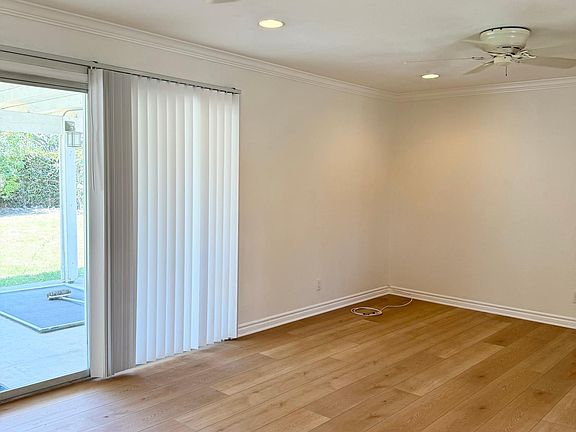 Living room, with large slider door to backyard with covered patio, ceiling fans, new vinyl plank flooring