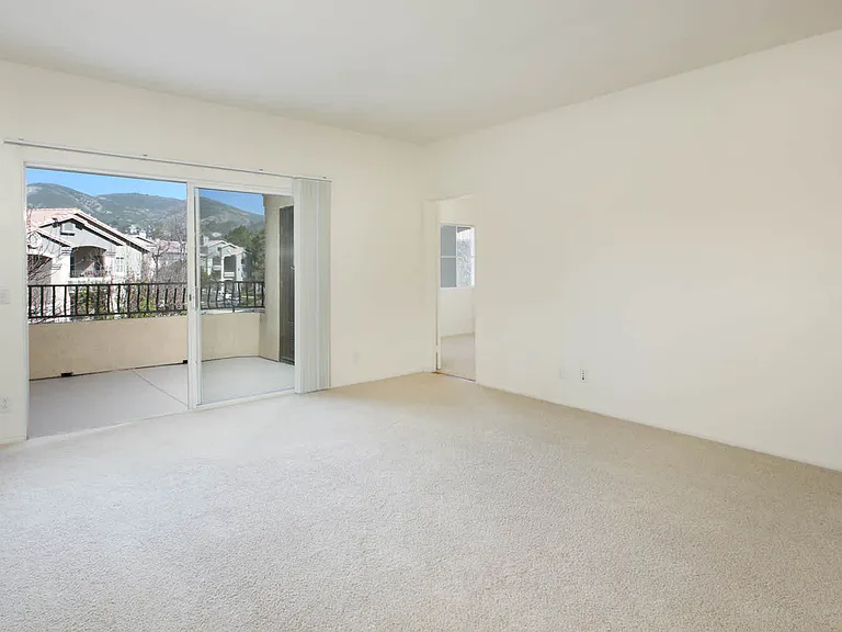 Carpeted Living Room with Balcony