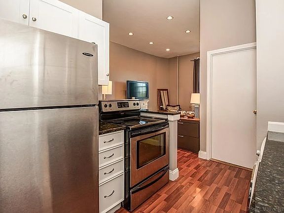 Fully-equipped kitchen offers all new white cabinets, stainless steel appliances and granite counters with a breakfast bar opening to living room.