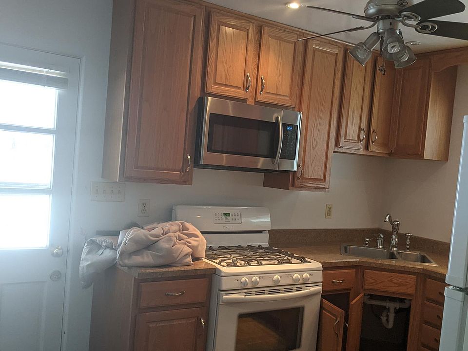 Equipped kitchen with oak cabinets dishwasher microwave gas stove and refrigerator