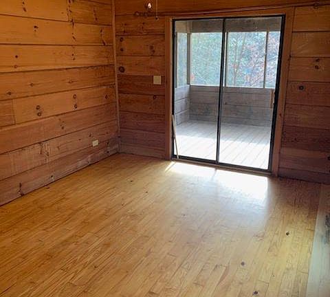 Living room with wood floors and real wood paneled walls and vaulted ceilings