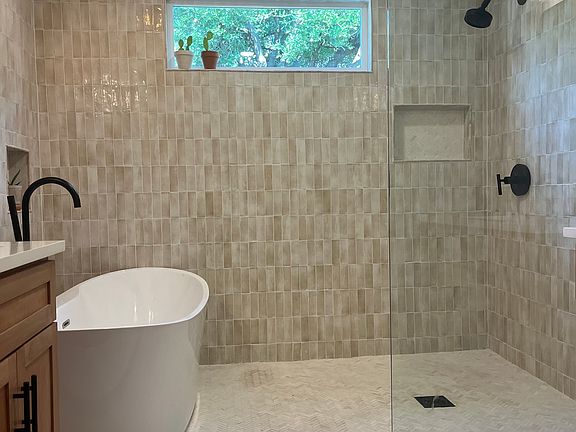 Bathroom with double vanity, freestanding tub, large walk-in shower, and dual shower heads