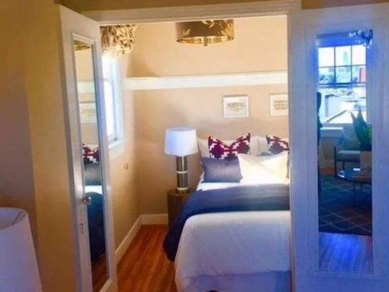 Potential furniture layout of bedroom space. Fits full/queen with space as seen in this pic or eastern king at full capacity. Corner shelves and dimmer chandelier. Tenant can paint bedroom to cozy up their style.