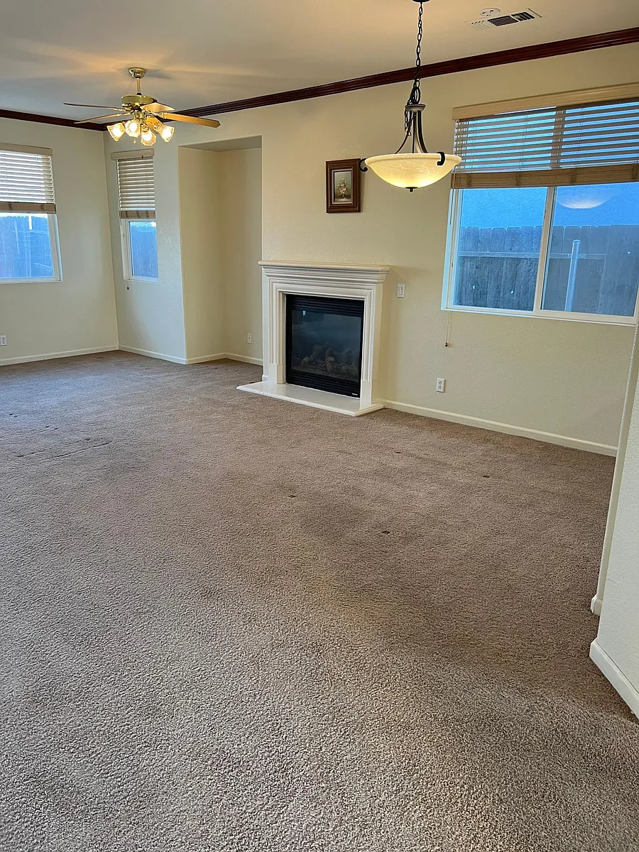 Living room with natural light, gas fireplace, and ceiling fan - 991 Beymer Loop