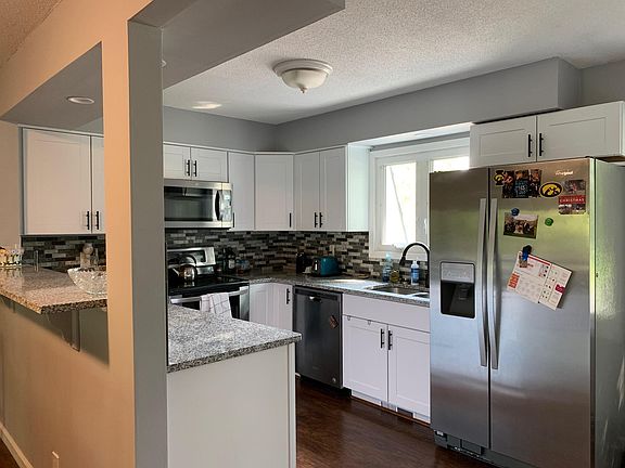 Open newer kitchen with granite countertops, dishwasher, disposal, pass through to dining room.