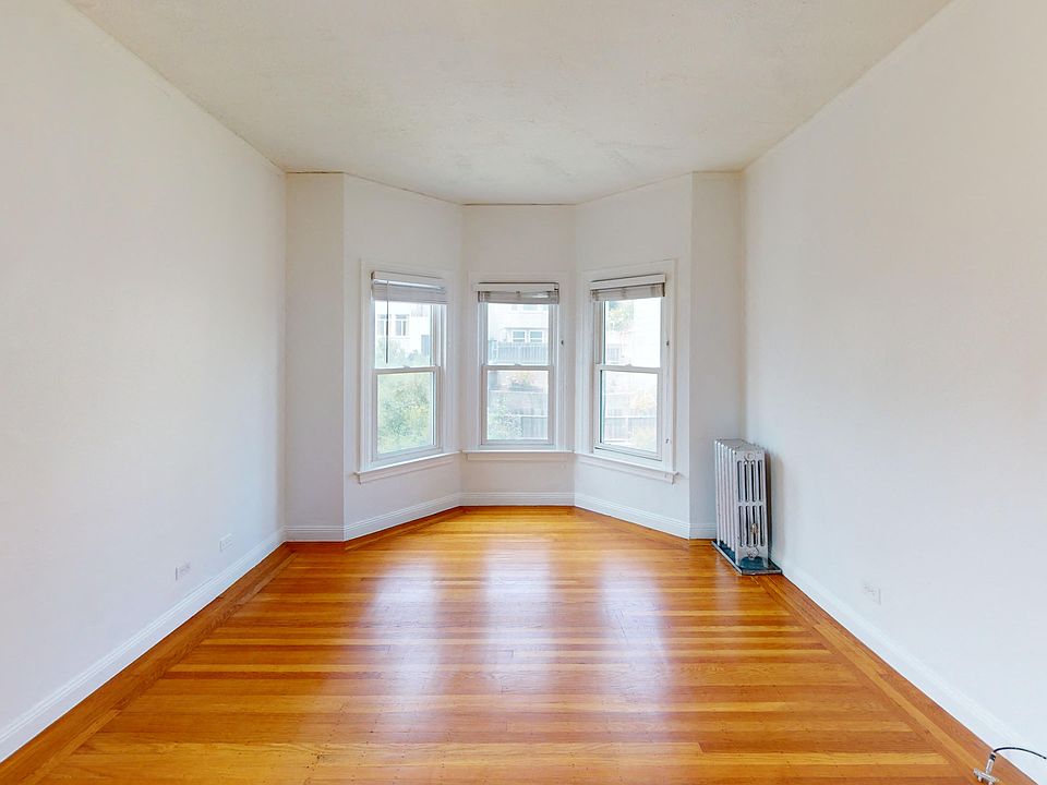 Sunlit room with a large window and a wood-like flooring