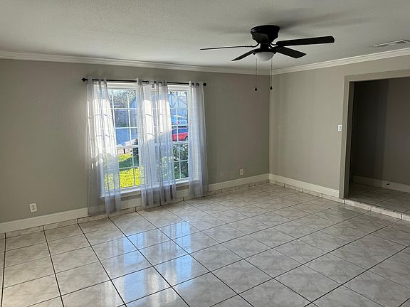 Large oversized family room, with large format white tile. New windows filling the space with nature light. New large black fan. This is the perfect space for family gatherings.