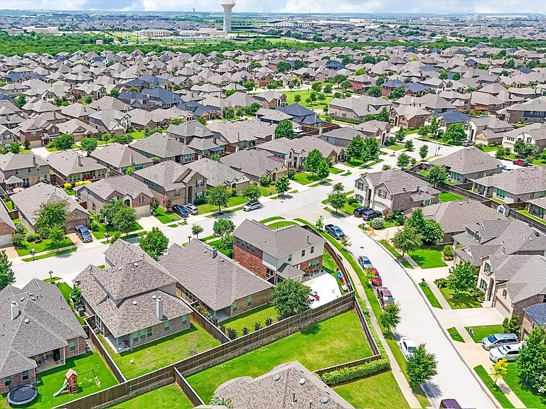 Sprawling residential neighborhood featuring a consistent architectural style, paved streets, and mature landscaping