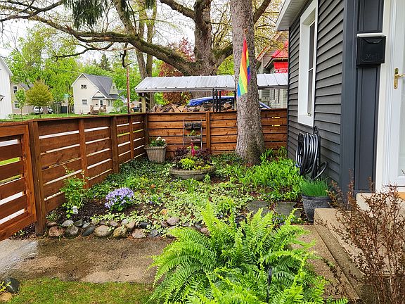 Beautifully landscaped side yard with garden hose