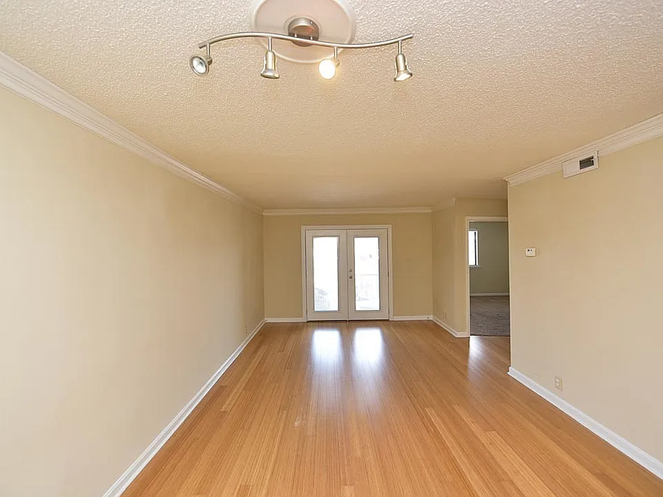 Experience the openness of this living room featuring stylish wood flooring and contemporary lighting.