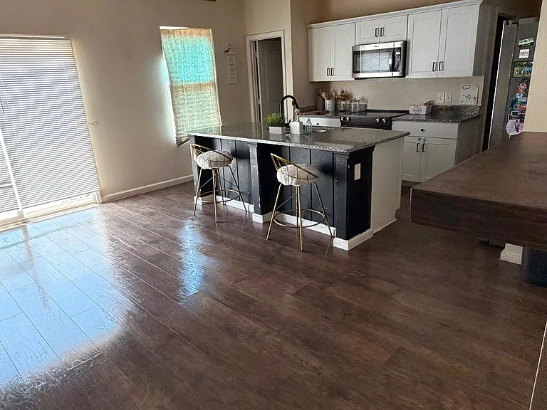 Open kitchen with a large island, breakfast seating, ample cabinetry, and stainless appliances for easy everyday cooking.