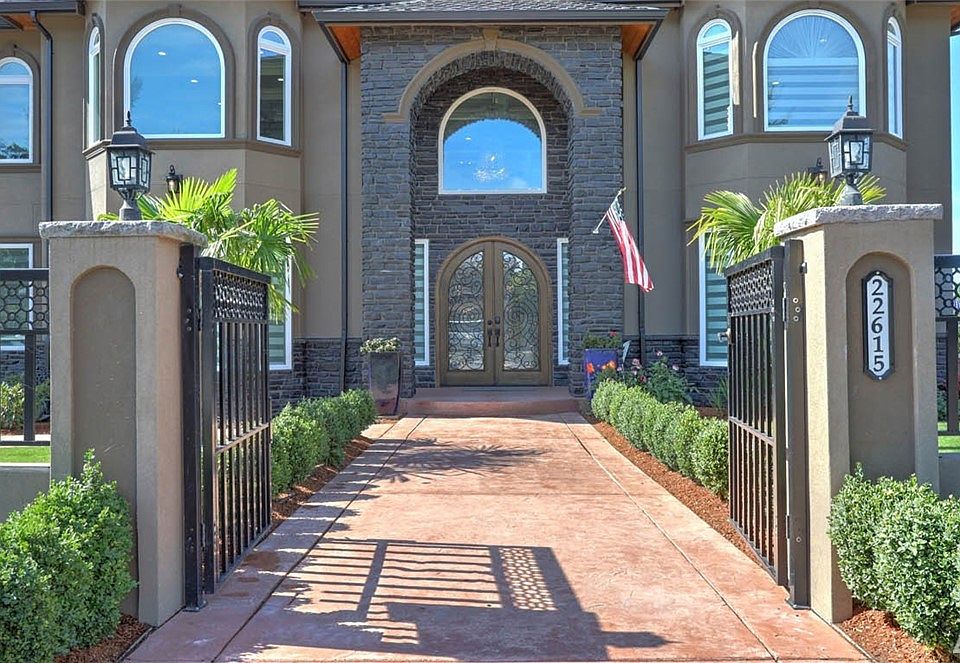 Dramatic gated entry with stamped concrete walks