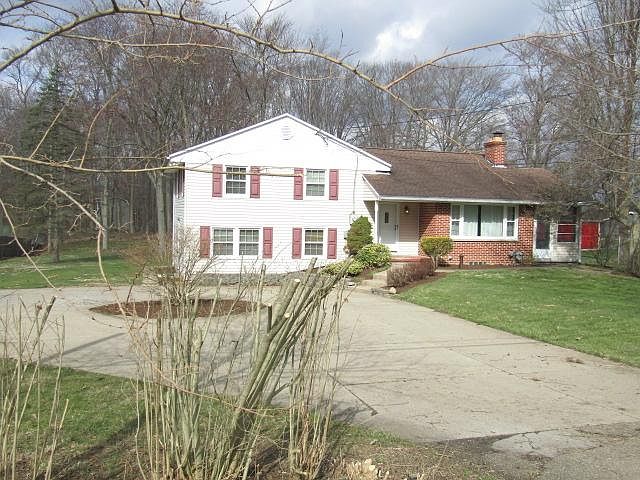 1638 S. Cleveland-Massillon Road is a tan sided home with brick facing and maroon shutters. It has a cement circular driveway and parking area.