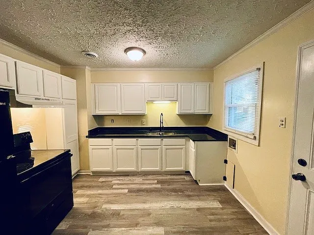 _ Freshly renovated cozy kitchen alert! Featuring sleek black appliances, stunning granite countertops, and warm laminate wood flooring_perfect for whipping up meals with style! __ #KitchenGoals #HomeRenovation #CozyLiving