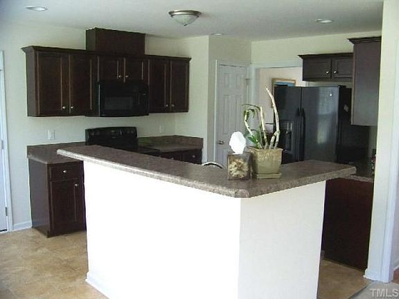Kitchen View 1, richly stained cabinets w/black appliances.