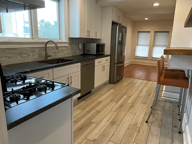 Bright updated kitchen with stainless steel appliances, gas range, recessed lighting, and a clean, modern layout.