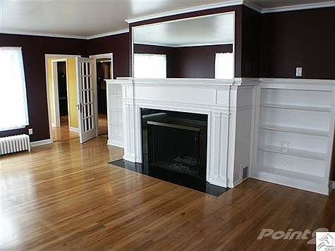 Beautiful original hardwoods, large windows, stately wood fireplace and built-ins