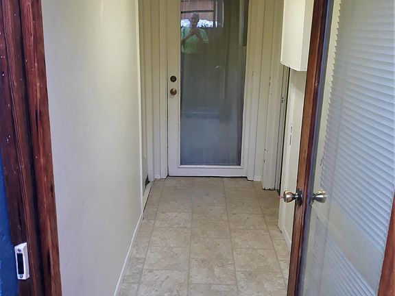 Basement entry hall: apartment door at end; shared utility room door on right; basement unit storage door on left.