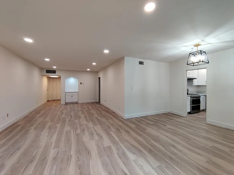View from sliding door of living room, dining area and unit entry.