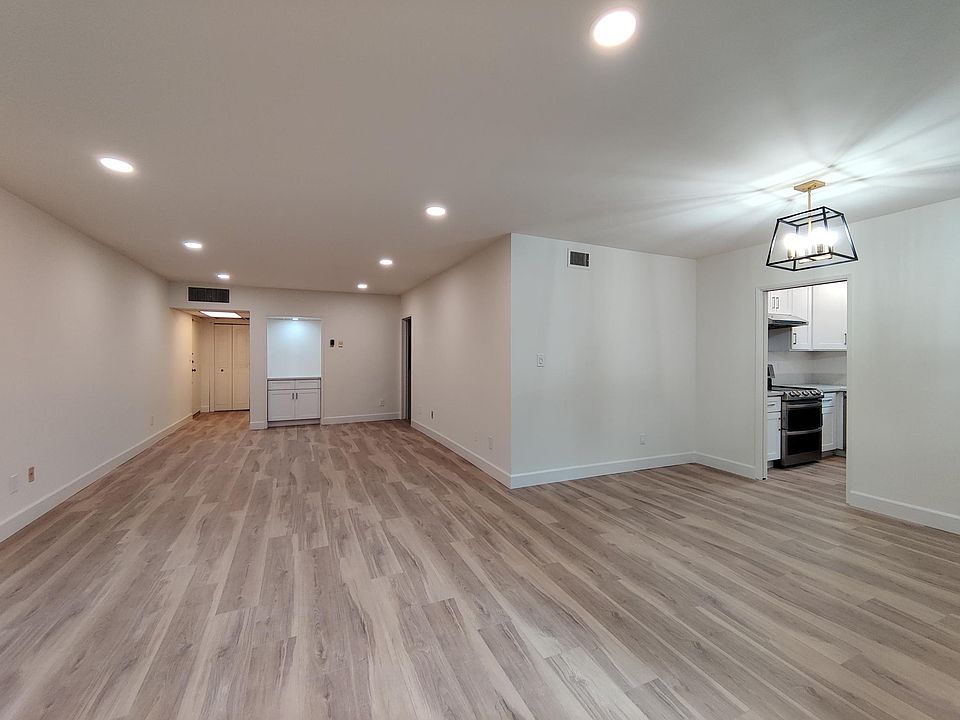View from sliding door of living room, dining area and unit entry.